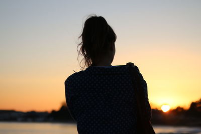 Rear view of woman looking at sunset