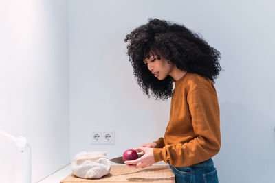 Rear view of woman having food at home