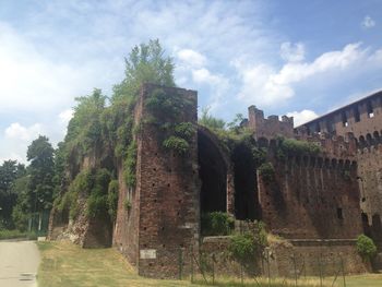 Low angle view of old ruin building against cloudy sky