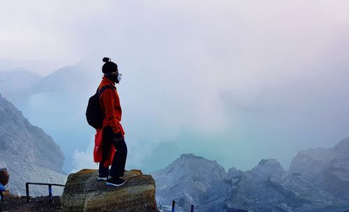 Rear view of man on snowcapped mountains against sky