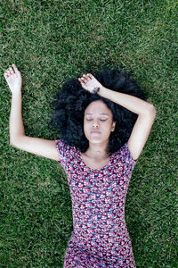 Portrait of young woman lying down on field
