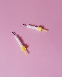 Close-up of pink cigarette over colored background