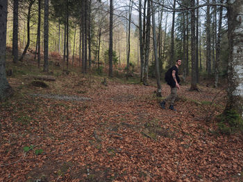 Man standing by leaves in forest