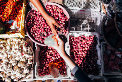 Cropped hands of people shopping vegetables at market stall