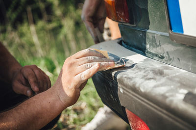 Cropped hands of person cleaning car