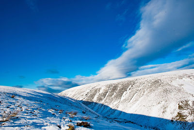 Scenic view of snowcapped mountain against blue sky