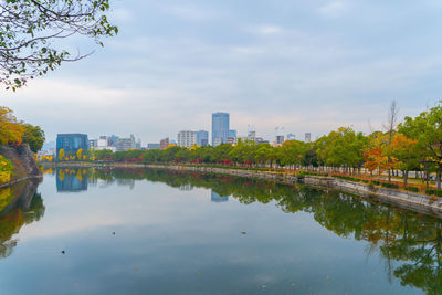 Scenic view of lake by buildings against sky