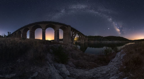 Arch bridge against sky at night