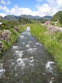Scenic view of river amidst mountains against sky