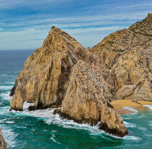 Scenic view of rock formation in sea against sky