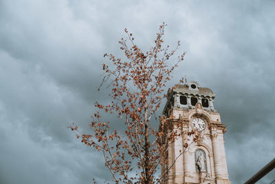 Low angle view of tree and building against sky