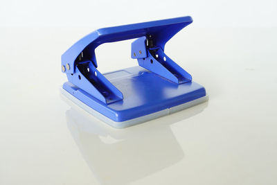 Close-up of blue hole puncher on white background