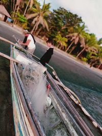 People sitting on boat moored in canal