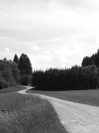 Road amidst field against sky