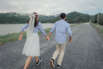 Rear view of couple walking on road
