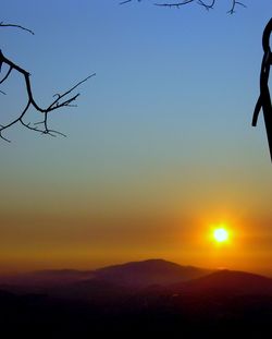 Scenic view of silhouette mountains against clear sky during sunset