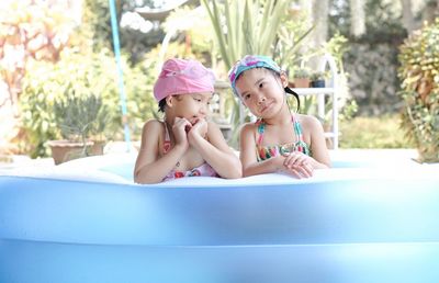 Portrait of cute girl sitting in swimming pool