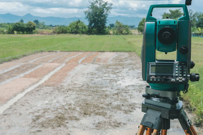 Close-up of camera on field against sky