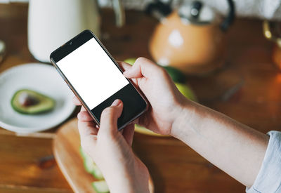 Midsection of man using mobile phone on table