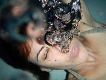 Close-up of woman swimming underwater in pool