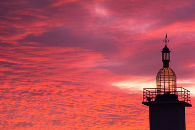 Tower in city against dramatic sky