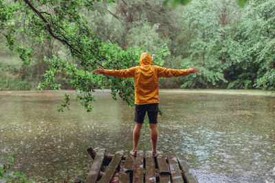 Rear view of boy standing in forest