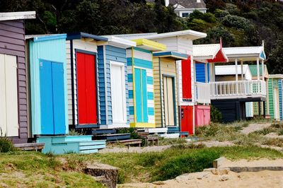 Colorful beach huts against trees