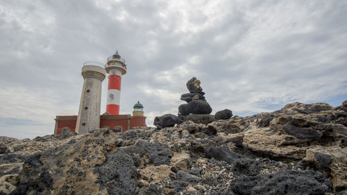 Low angle view of lighthouse on beach against sky