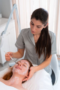 Young woman giving massage to patient