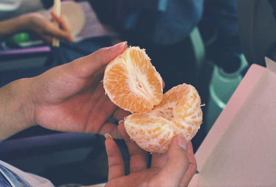 Close-up of hand peeling orange