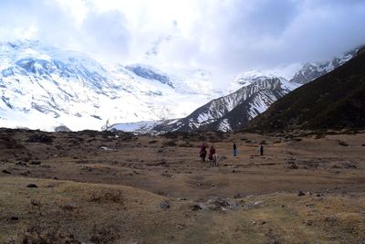 People on mountain against sky