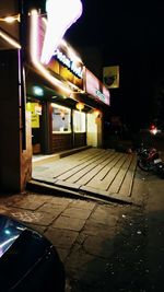 Illuminated city street during rainy season at night