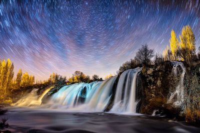Long exposure of waterfall against sky at night