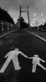 Road sign on bridge in city at night