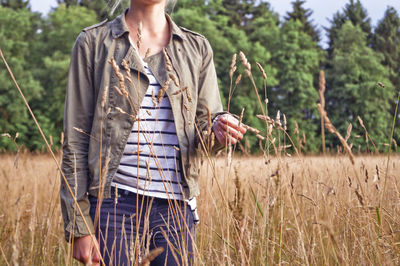 Midsection of woman standing on agricultural field