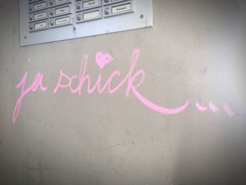 Close-up of text on pink wall
