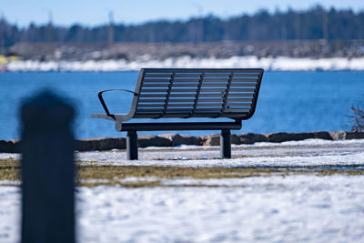 Empty bench on snow covered land