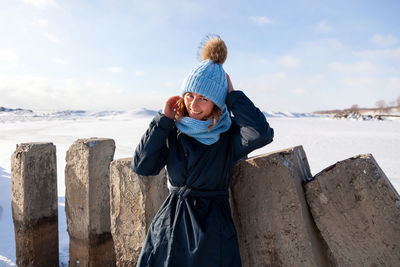 Rear view of man standing at beach during winter