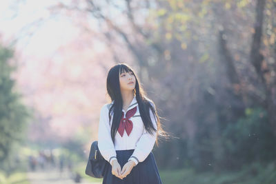 Young woman standing against the sky