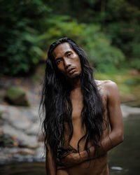 Portrait of young man standing against blurred background