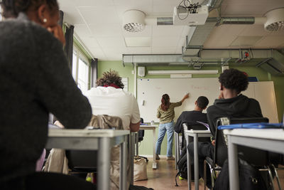 Rear view of business people working in office