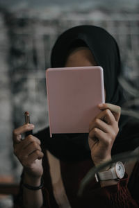 Close-up of woman wearing hijab applying make-up