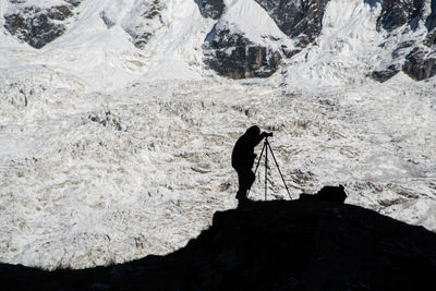 A photographer in annapurna sanctuary in nepal capturing the early morning on the distant mountains