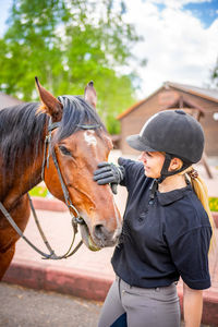 Young woman with horse standing outdoors