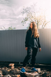 Portrait of young woman standing against plants