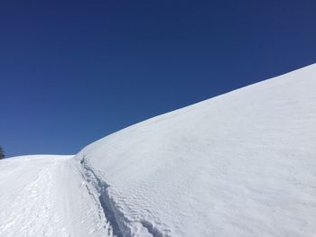 Scenic view of snowcapped mountains against blue sky