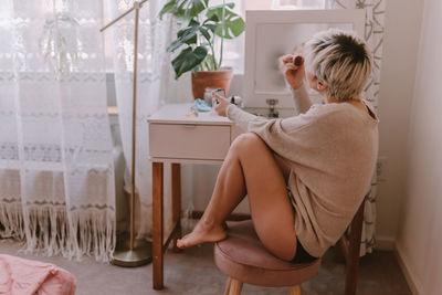 Woman sitting on chair at home