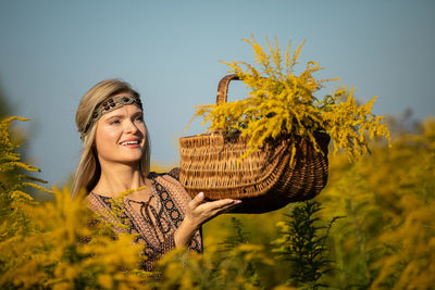 Portrait of young woman standing amidst plants