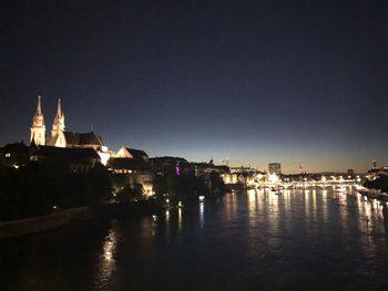 River amidst illuminated buildings against sky at night