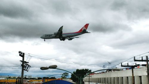 Low angle view of airplane flying against sky